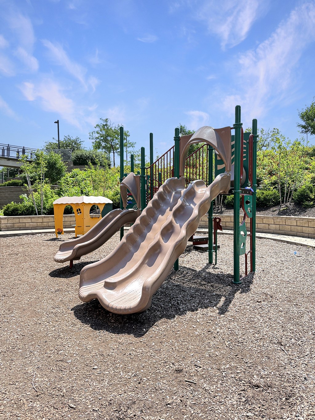 A playground with a slide and a yellow object.