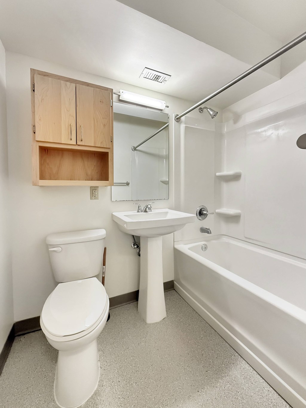 A white toilet sits next to a sink in a small bathroom.