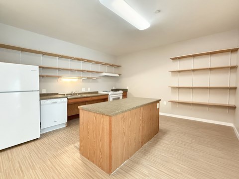 A kitchen with a white refrigerator and a wooden island.