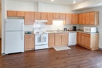A kitchen with wooden cabinets and white appliances.