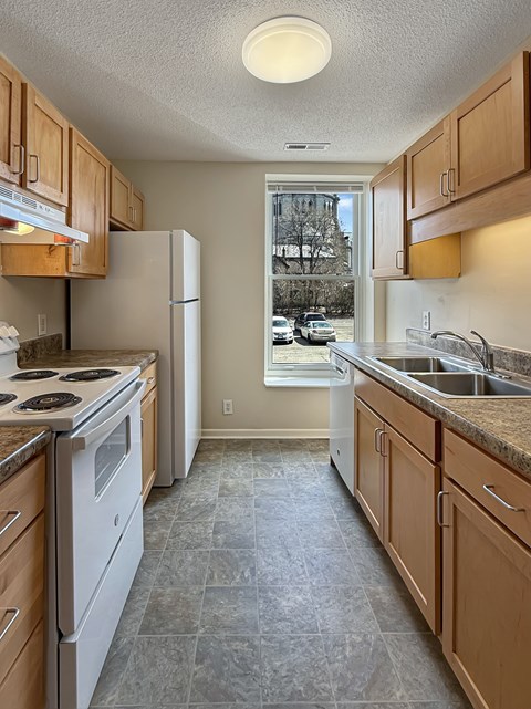 A kitchen with a white stove top oven and white refrigerator.