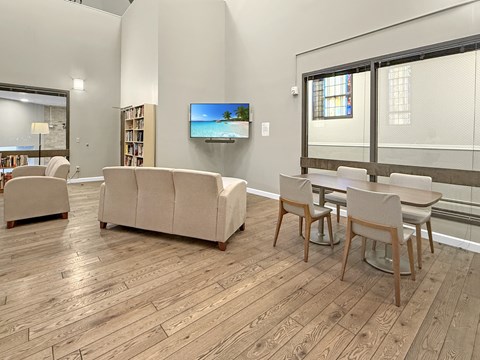 A living room with a couch, chairs, and a television.