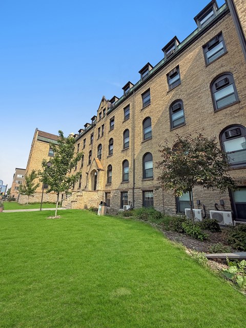 A large grassy area in front of a brick building.