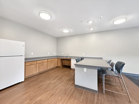 A kitchen with a white refrigerator and a table with chairs.