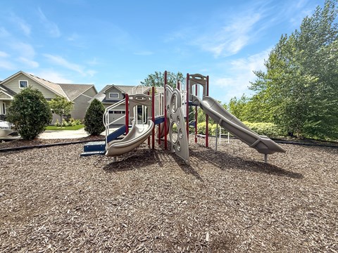 A playground with a slide and a climbing frame.