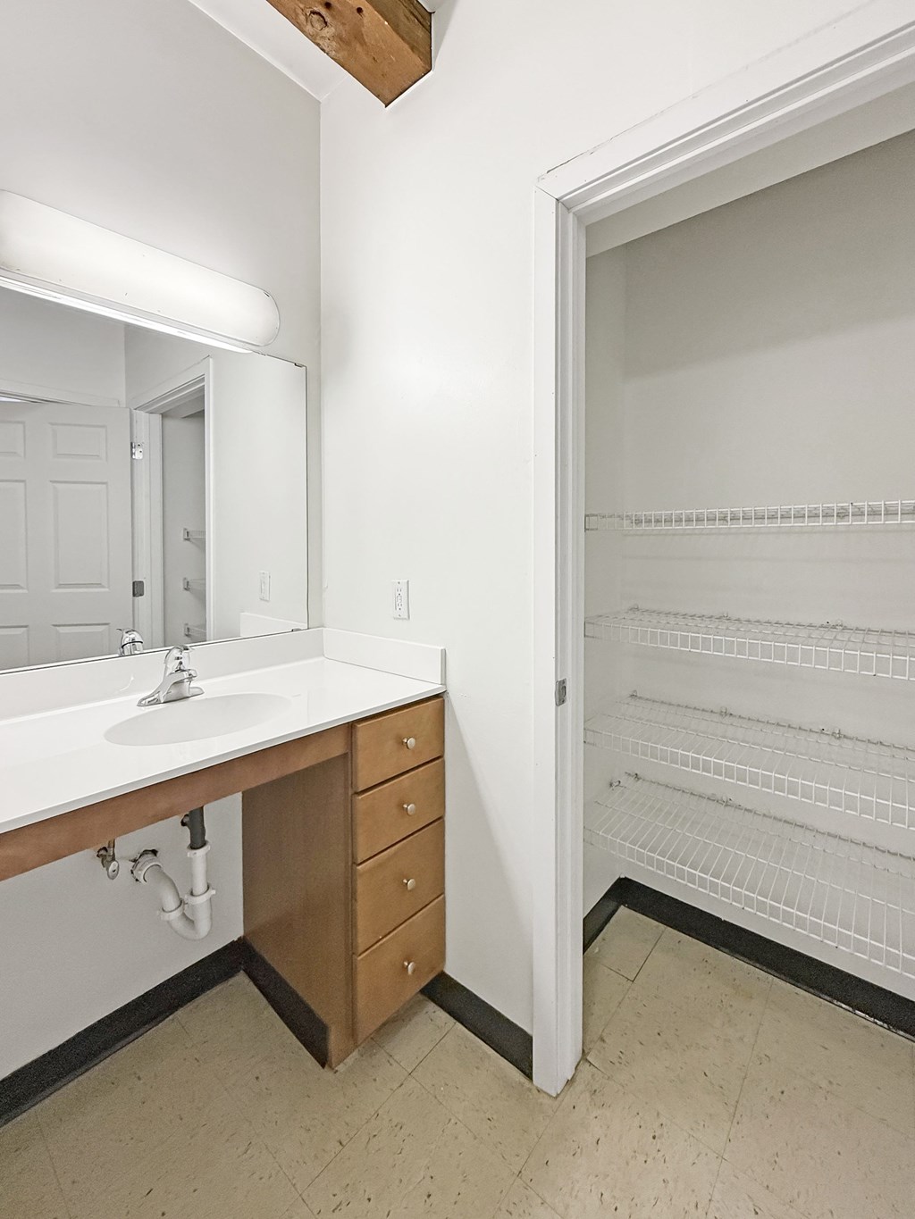 A white bathroom with a sink and an open white fridge.