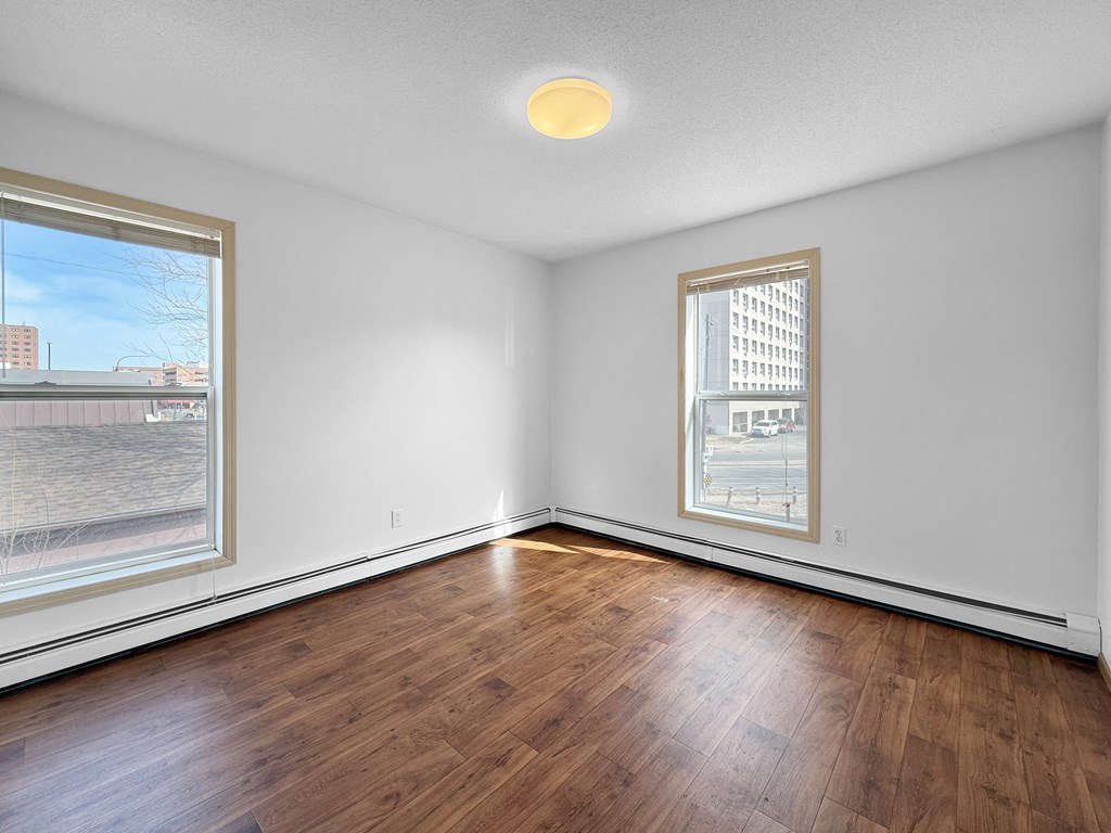 A room with a window and a wooden floor.