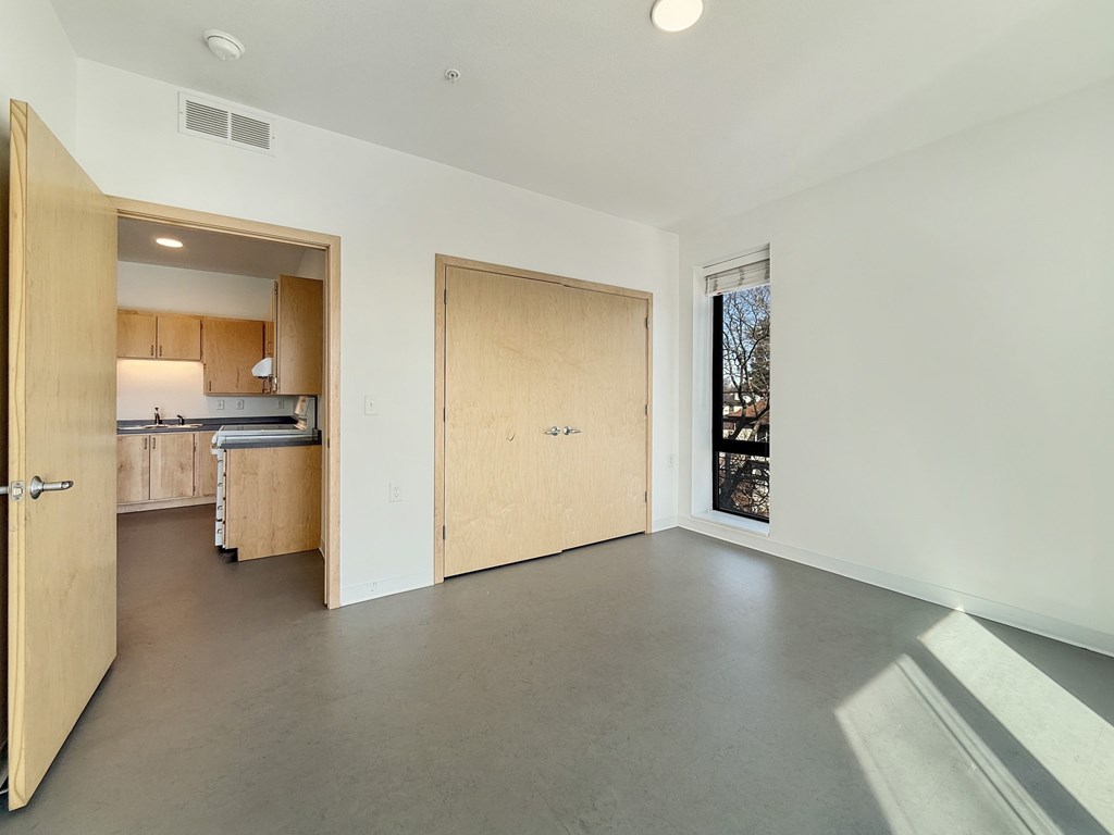 A room with a white wall and a brown door.