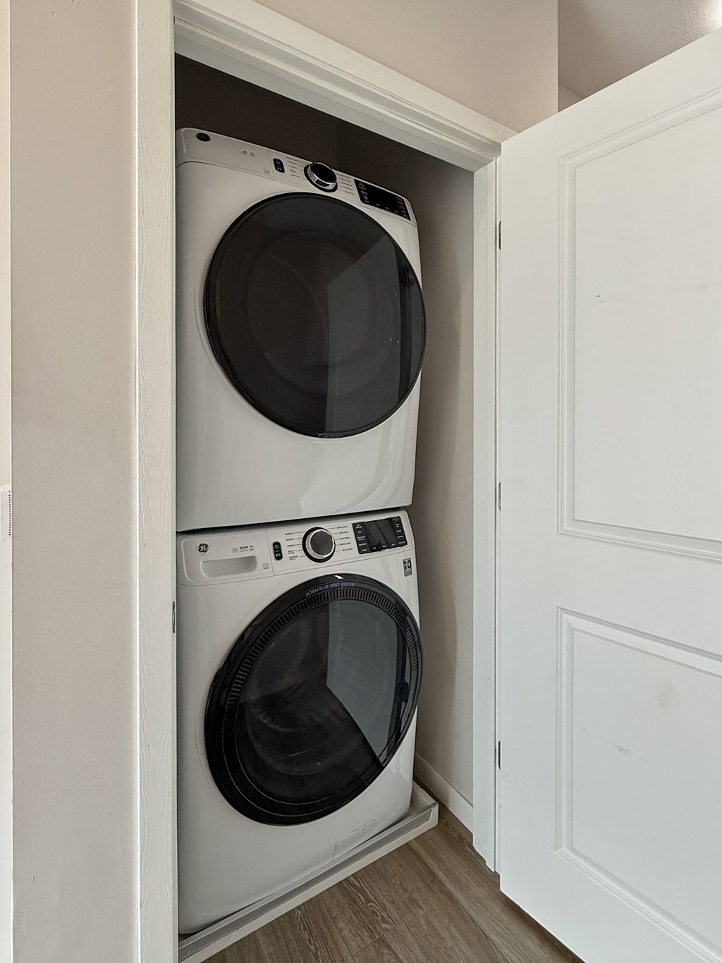 Two white front loading washing machines in a small laundry room.