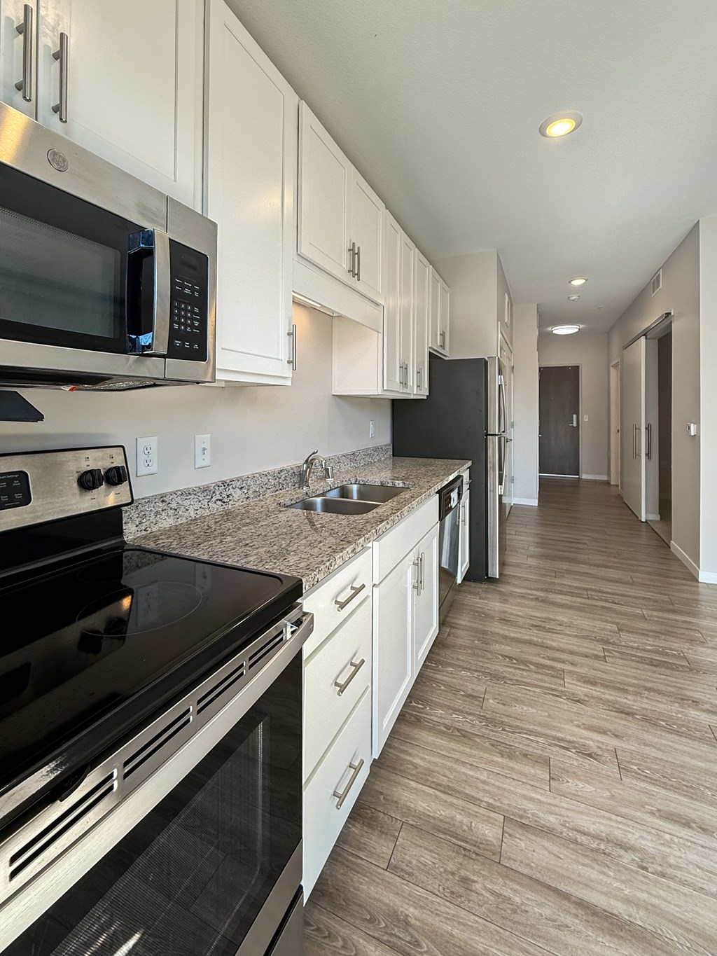 A kitchen with a black stove top oven and white cabinets.