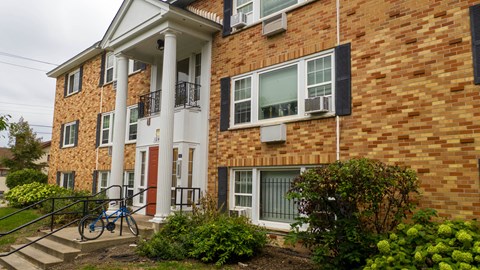 A brick building with a white door and windows.