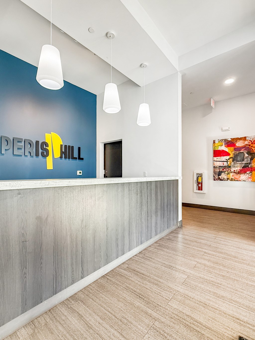 A reception area with a blue wall and a white reception desk.