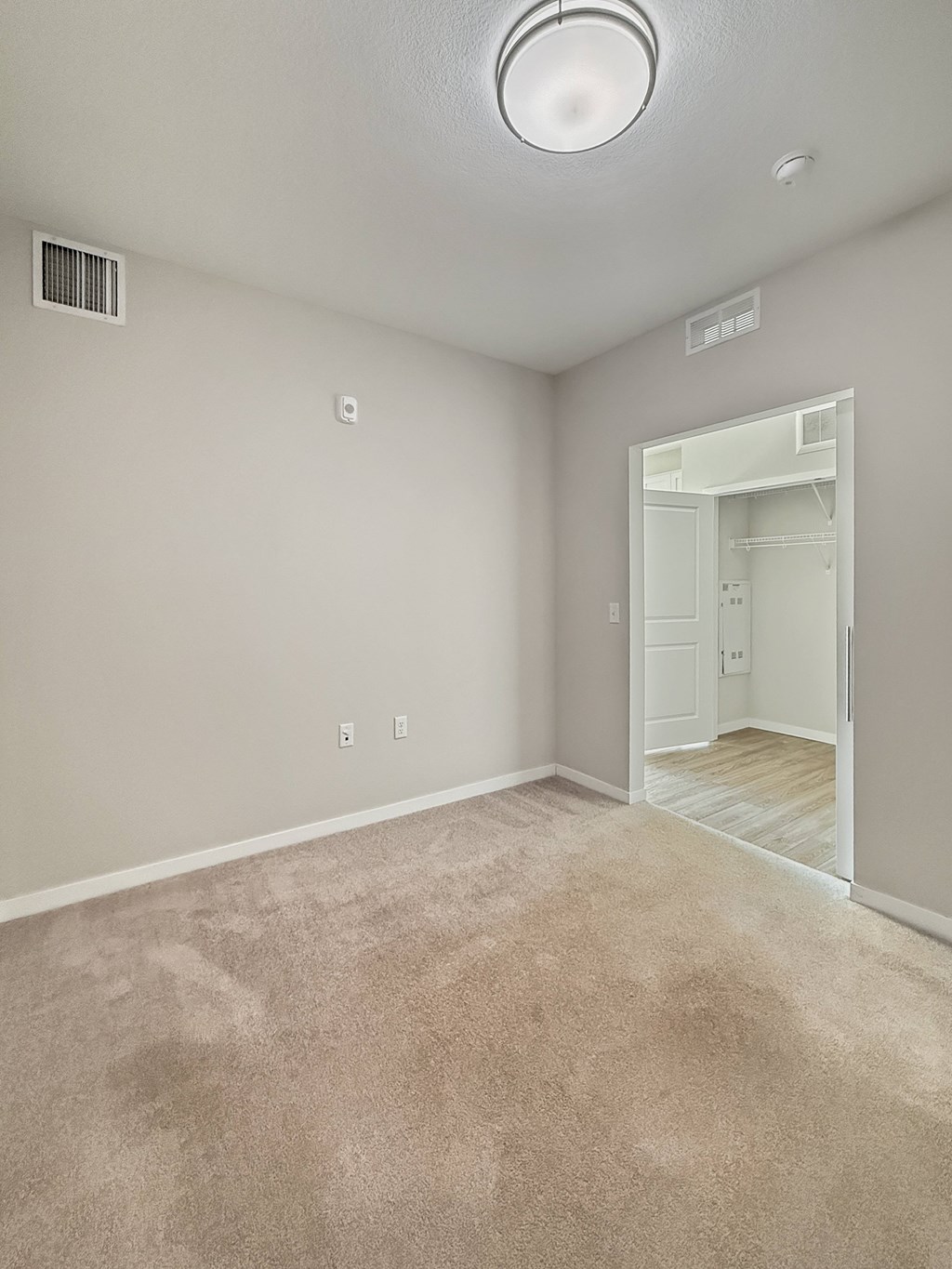 A room with a carpeted floor and a white door.