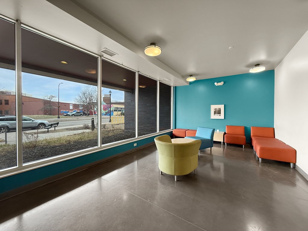 The front lobby of West Broadway Crecent with a blue wall and a yellow chair.