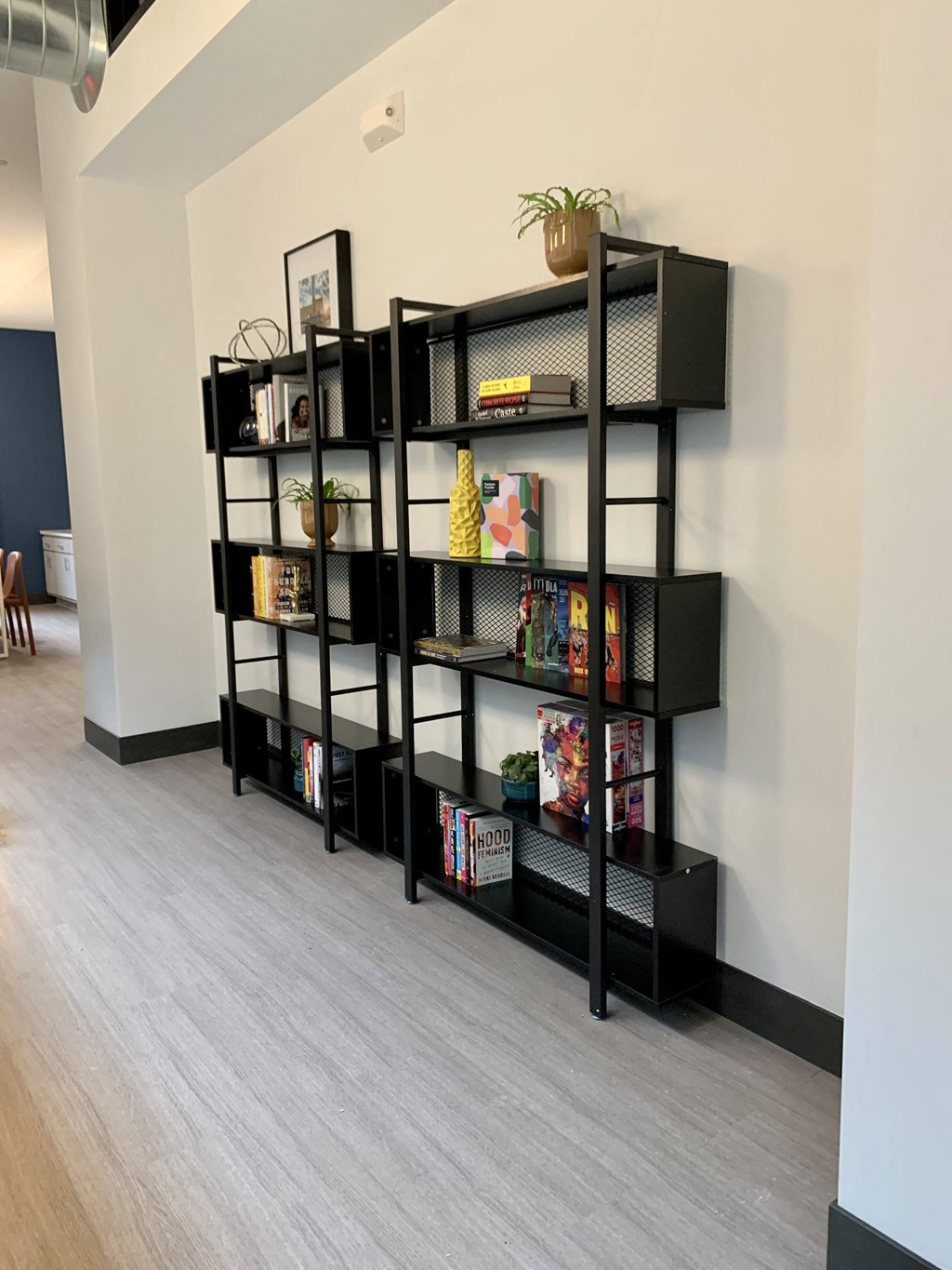 a bookshelf in the corner of a room with a wood floor
