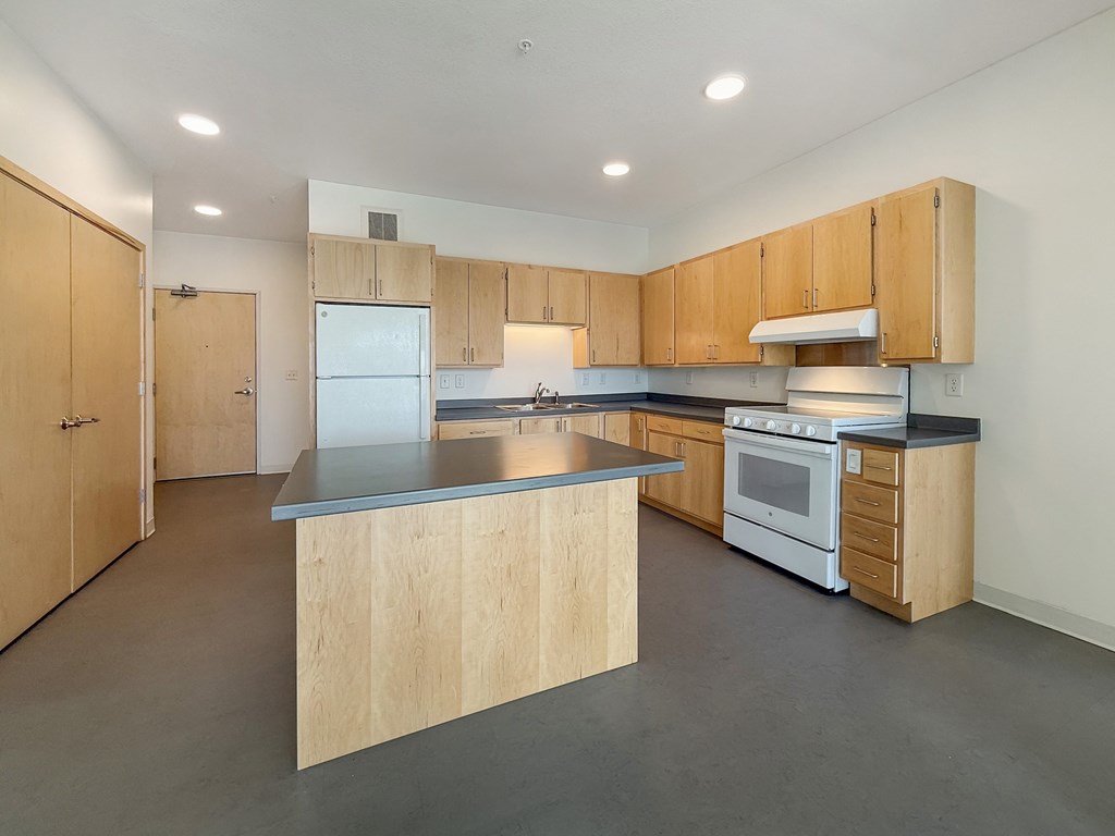 A kitchen with wooden cabinets and a large island.