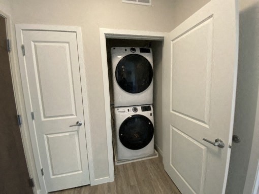 A white washing machine is in a small alcove between two doors.