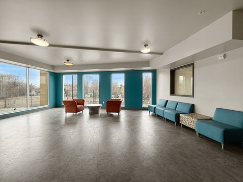 A spacious room with a long couch and a table with chairs.