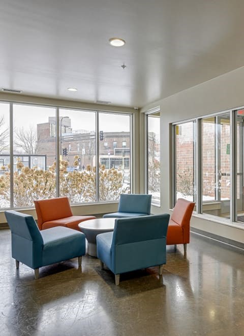 the lobby with four chairs and a table in front of a window.