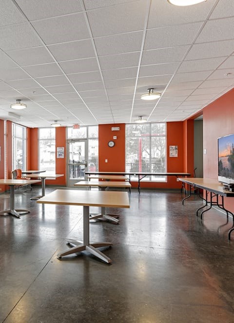 A community lobby with tables and chairs and a bench.