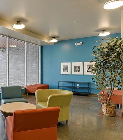 A room with blue walls and a large window with blinds.