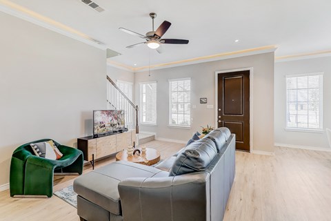 A living room with a grey couch and a green armchair.