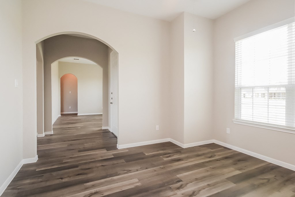 a living room with a hard wood floor and an arched doorway