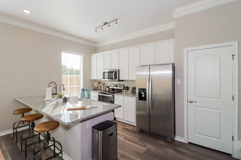 a kitchen with stainless steel appliances and a marble counter top