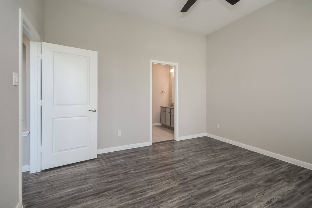 a living room with a white door and wood flooring