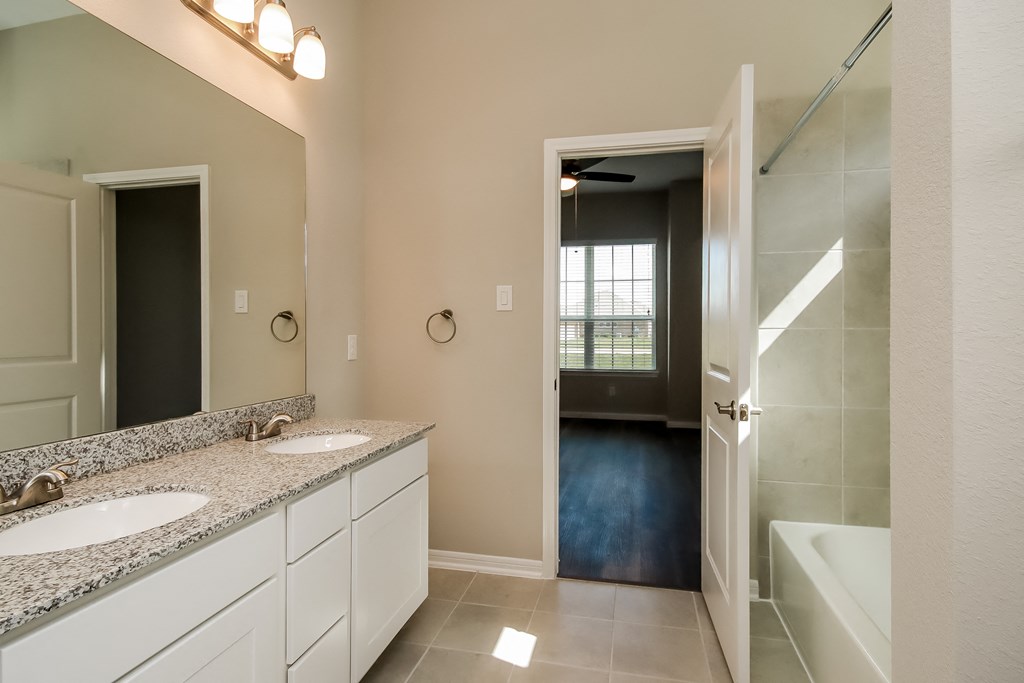 a bathroom with two sinks and a shower and a tub