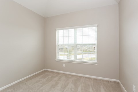 A room with a window and a car parked outside.