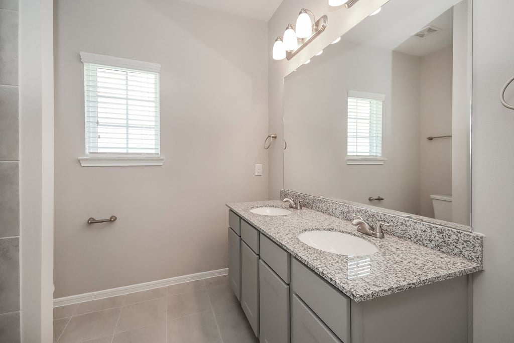 an empty bathroom with two sinks and a mirror