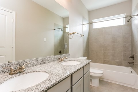 A bathroom with a marble countertop and a white toilet.