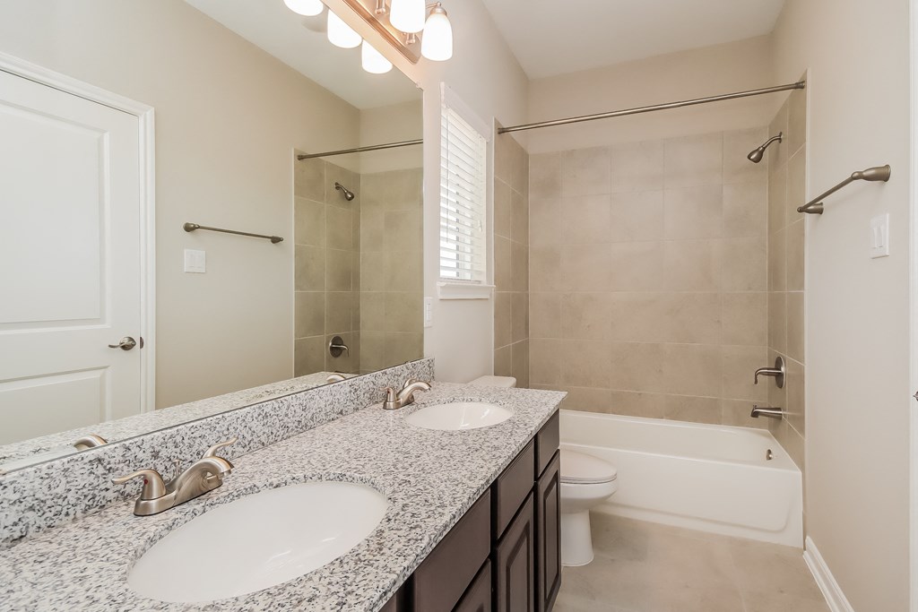 a bathroom with two sinks and a shower and a toilet