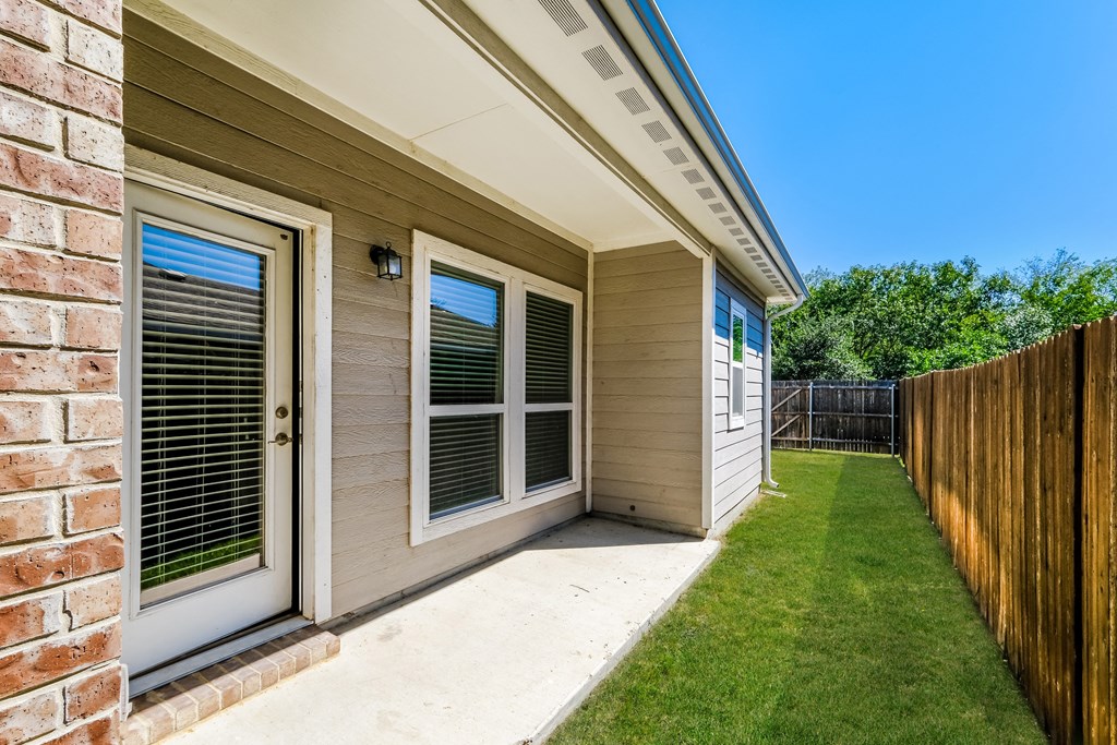a side view of a house with a patio and a yard