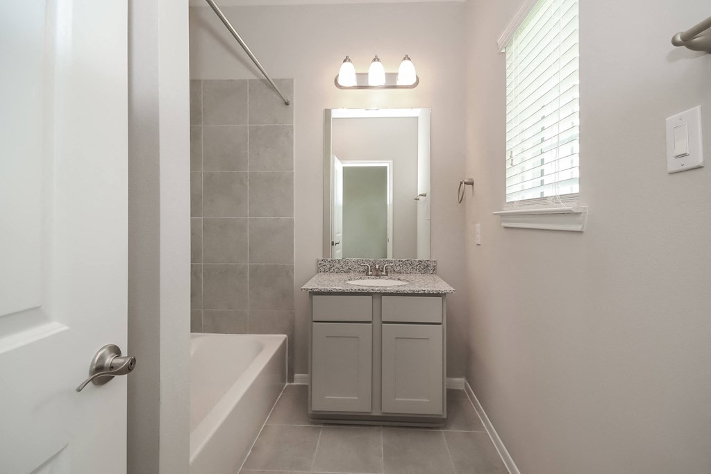 a bathroom with a sink and a tub and a mirror