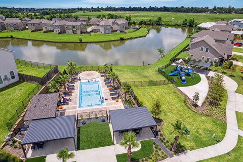 A swimming pool surrounded by houses and a fence.