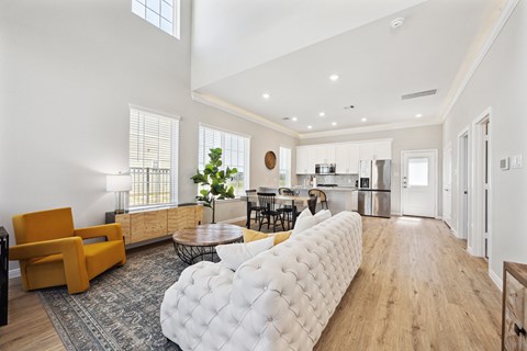 A modern living room with a white tufted sofa and a yellow armchair.