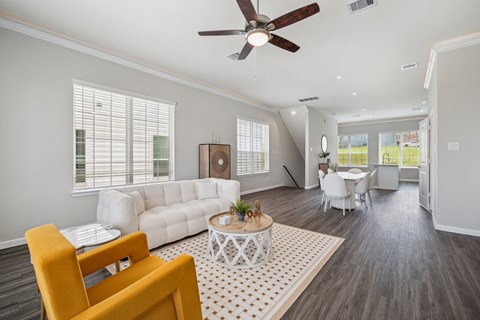 A living room with a white couch, a yellow chair, and a coffee table.