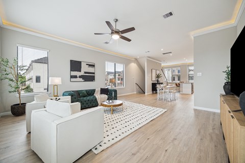 A living room with a white couch and a ceiling fan.