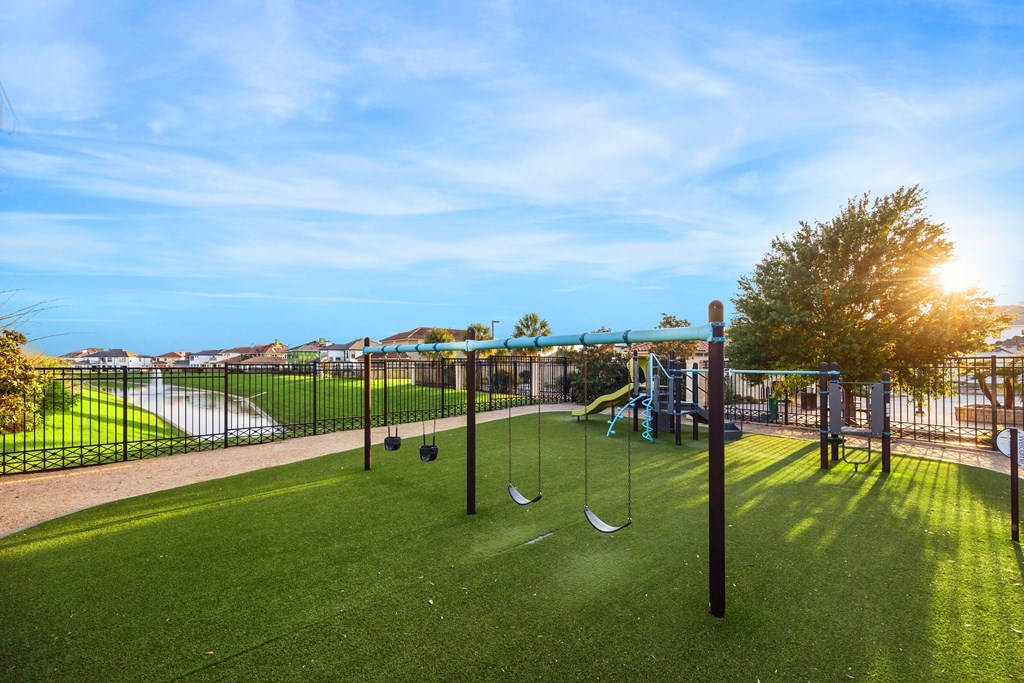 A playground with a slide, swings, and a tee-ball set.