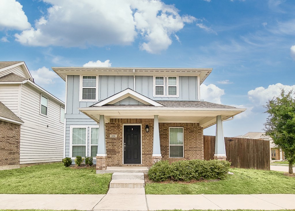 a small brick house with a black door