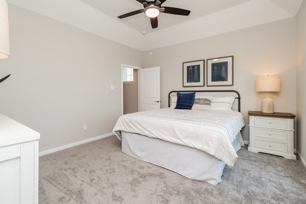 a bedroom with a bed and a ceiling fan