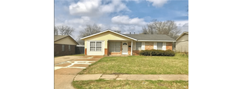 a small yellow house with a lawn and a driveway