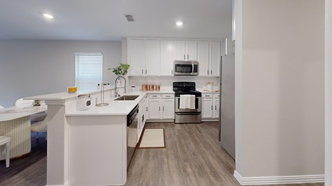 A white kitchen with a dining table and chairs.