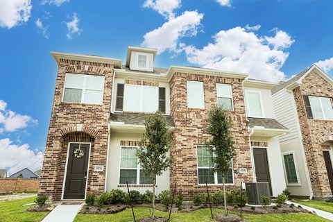 A large house with a black door and a brick facade.