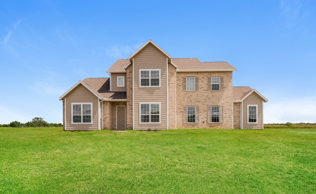 a large house with a green lawn in front of it