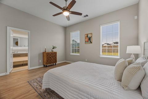 A bedroom with a large bed and a ceiling fan.