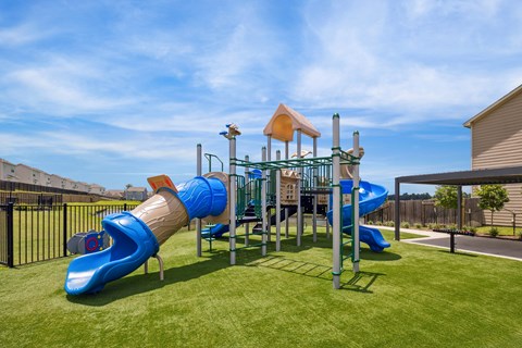 A playground with a blue slide and a yellow tower.