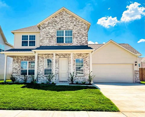 A house with a stone facade and a white garage door.
